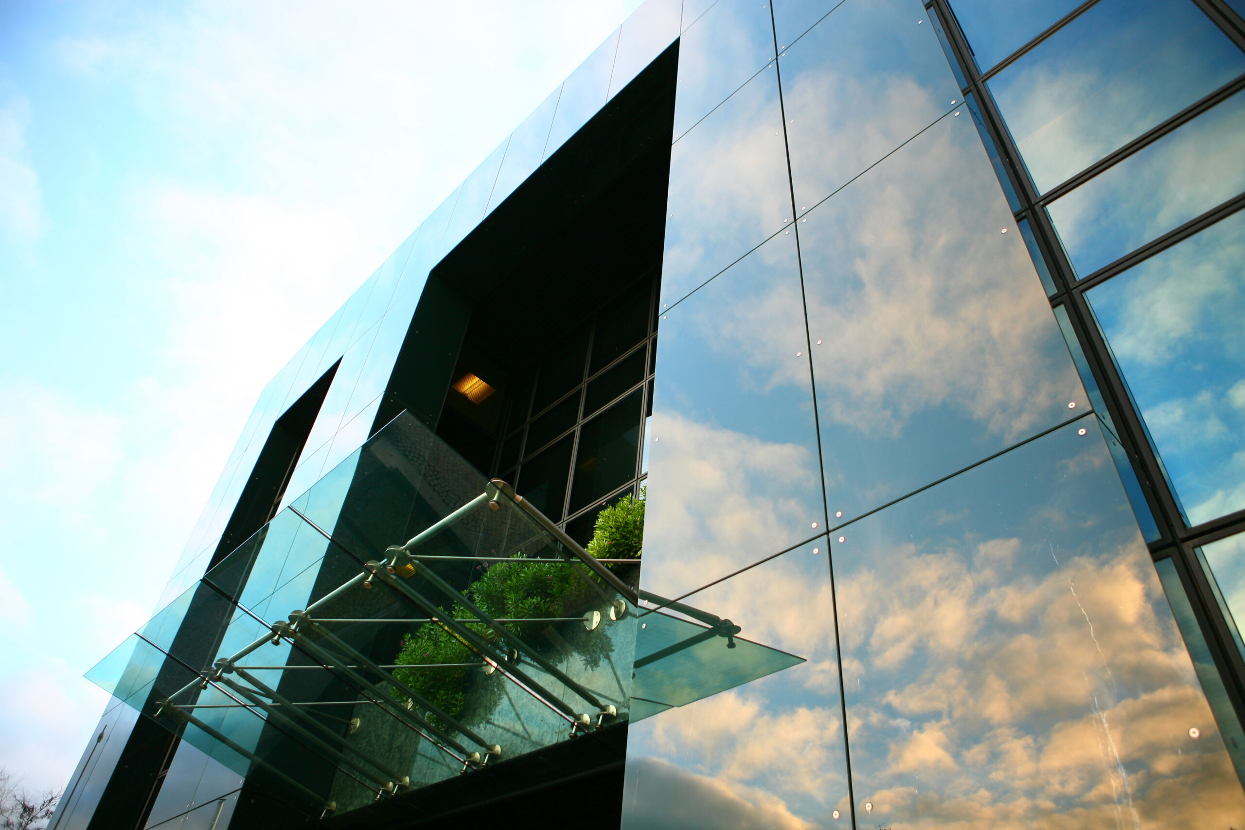 Edifício moderno com reflexos de nuvens.