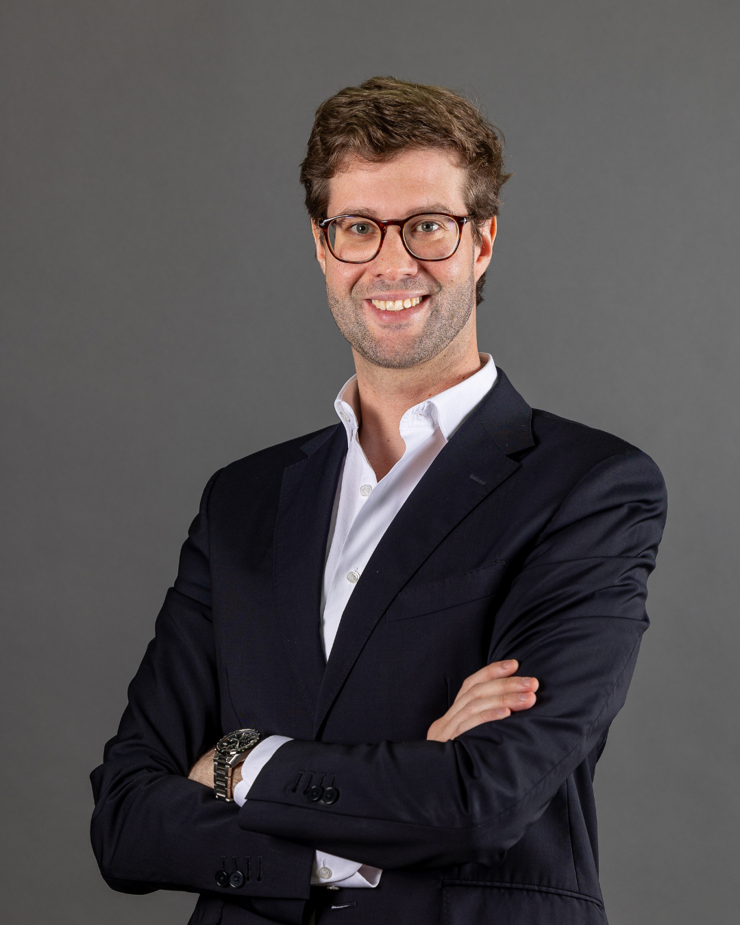 Homem de fato com braços cruzados.