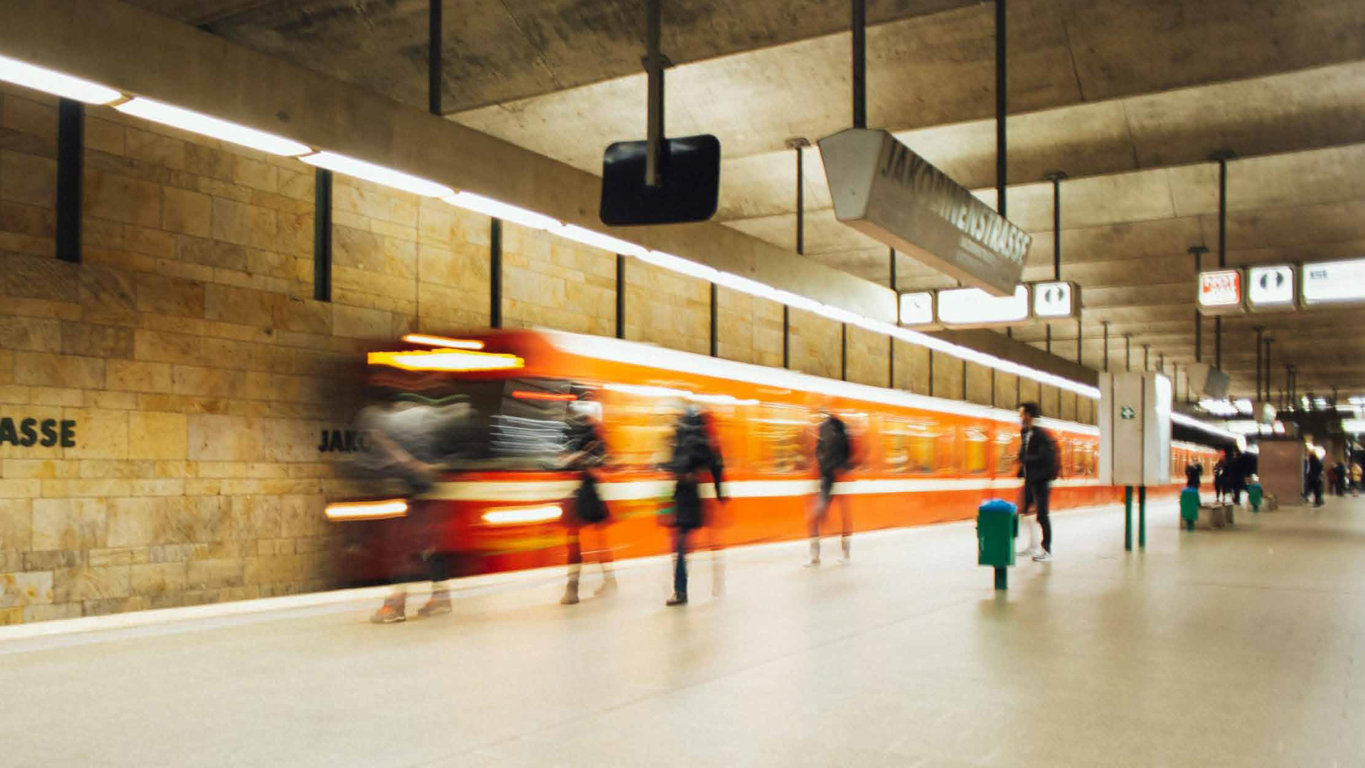 Trem laranja passando na estação